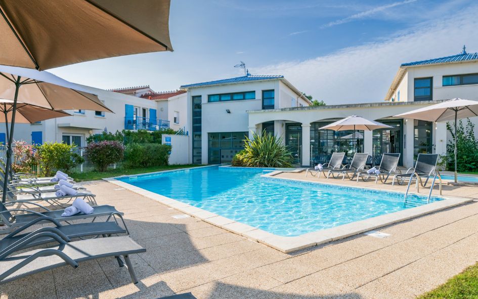 Espace extérieur de la résidence Les Carrelets avec piscine transats et parasols