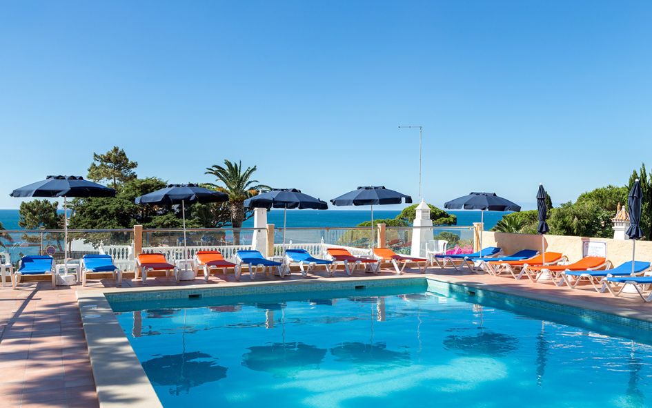 Piscine extérieure avec vue sur la mer transats et parasols à disposition à la résidence Do Parque